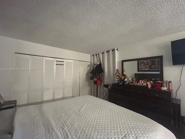 a bedroom with a bed and a flat tv screen