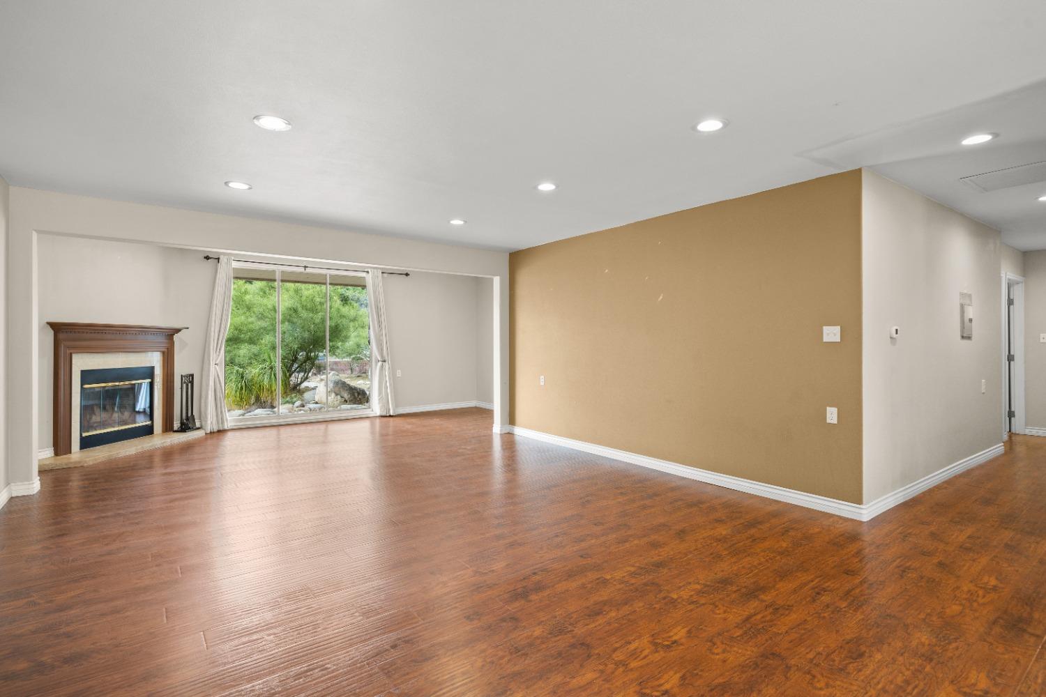 272 Rockaway Road Oak View, CA 93022 - Photo 22 of 33 an empty room with wooden floor fireplace and windows