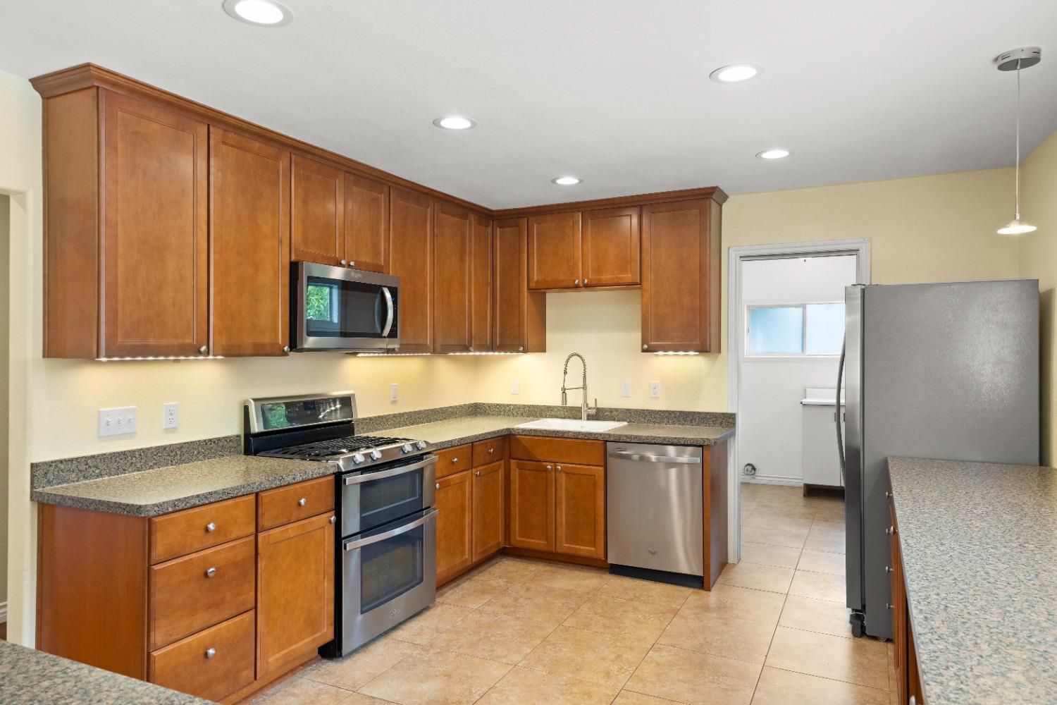 272 Rockaway Road Oak View, CA 93022 - Photo 10 of 33 a kitchen with stainless steel appliances granite countertop wooden cabinets a sink a stove a microwave and a refrigerator