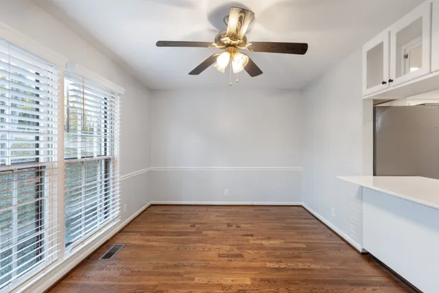 a view of an empty room with window and wooden floor
