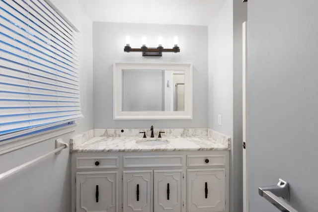 a view of a house with a small yard and large tree