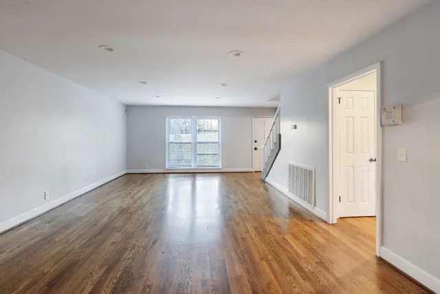a view of a livingroom with wooden floor and a fireplace