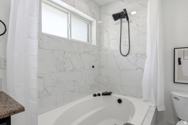120 North 1230 E Street Springville, UT 84663 - Photo 20 of 60 Bathtub and shower combination featuring white large-format tile with subtle veining, a built-in tub, a transom window, and a matte black shower fixture
