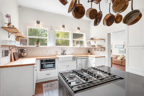 a kitchen with a stove a sink and a window