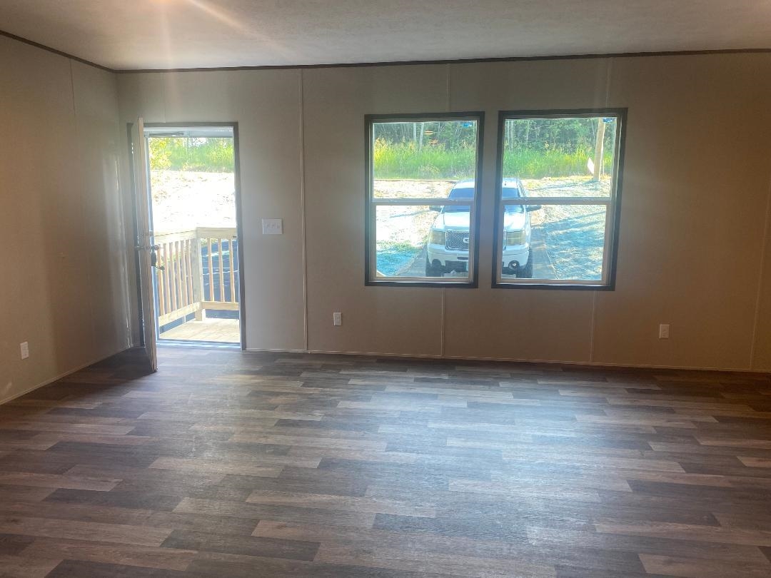 106 Simmons Road Munford, TN 38058 - Photo 19 of 30 Wood-finish flooring throughout, multiple windows, and a permanent exterior door leading to a wooden deck