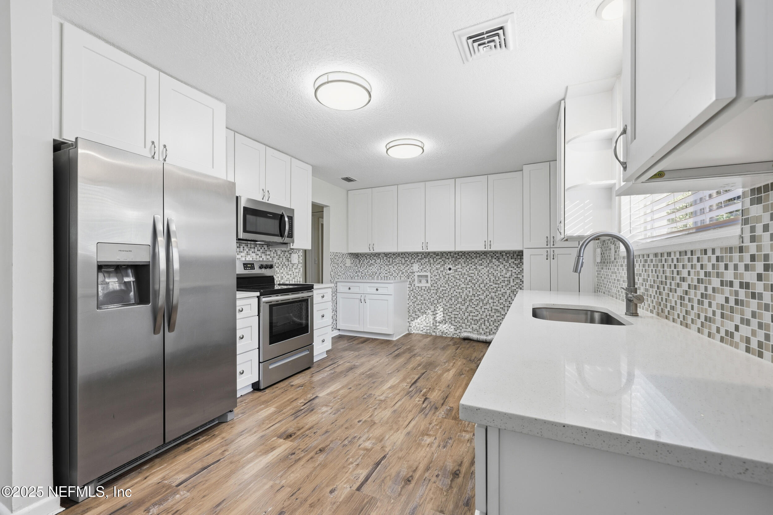 5201 Royce Avenue Jacksonville, FL 32205 - Photo 11 of 34 a kitchen with stainless steel appliances kitchen island granite countertop a sink refrigerator and cabinets