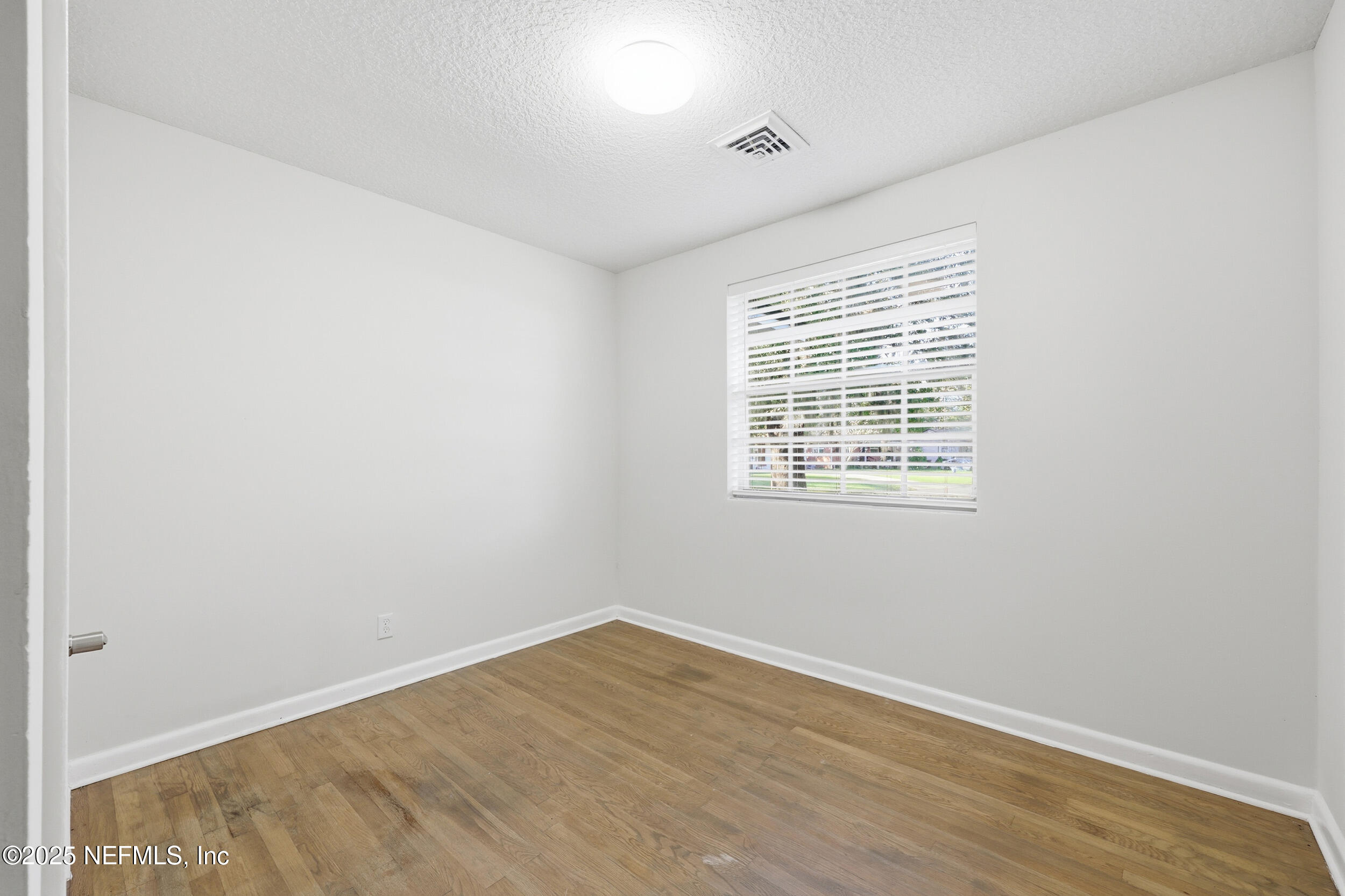 5201 Royce Avenue Jacksonville, FL 32205 - Photo 17 of 34 an empty room with wooden floor and windows