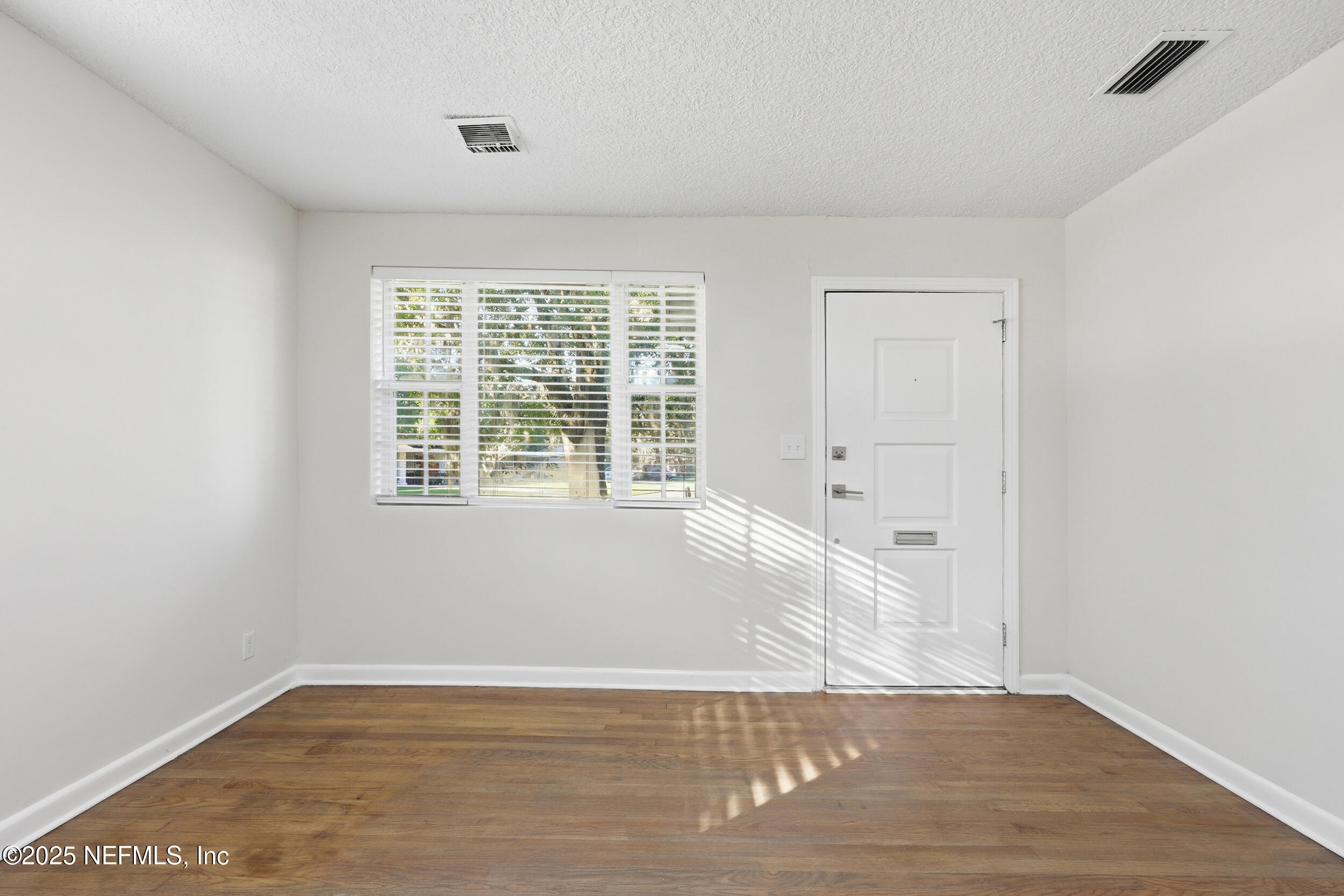 5201 Royce Avenue Jacksonville, FL 32205 - Photo 3 of 34 an empty room with wooden floor and windows