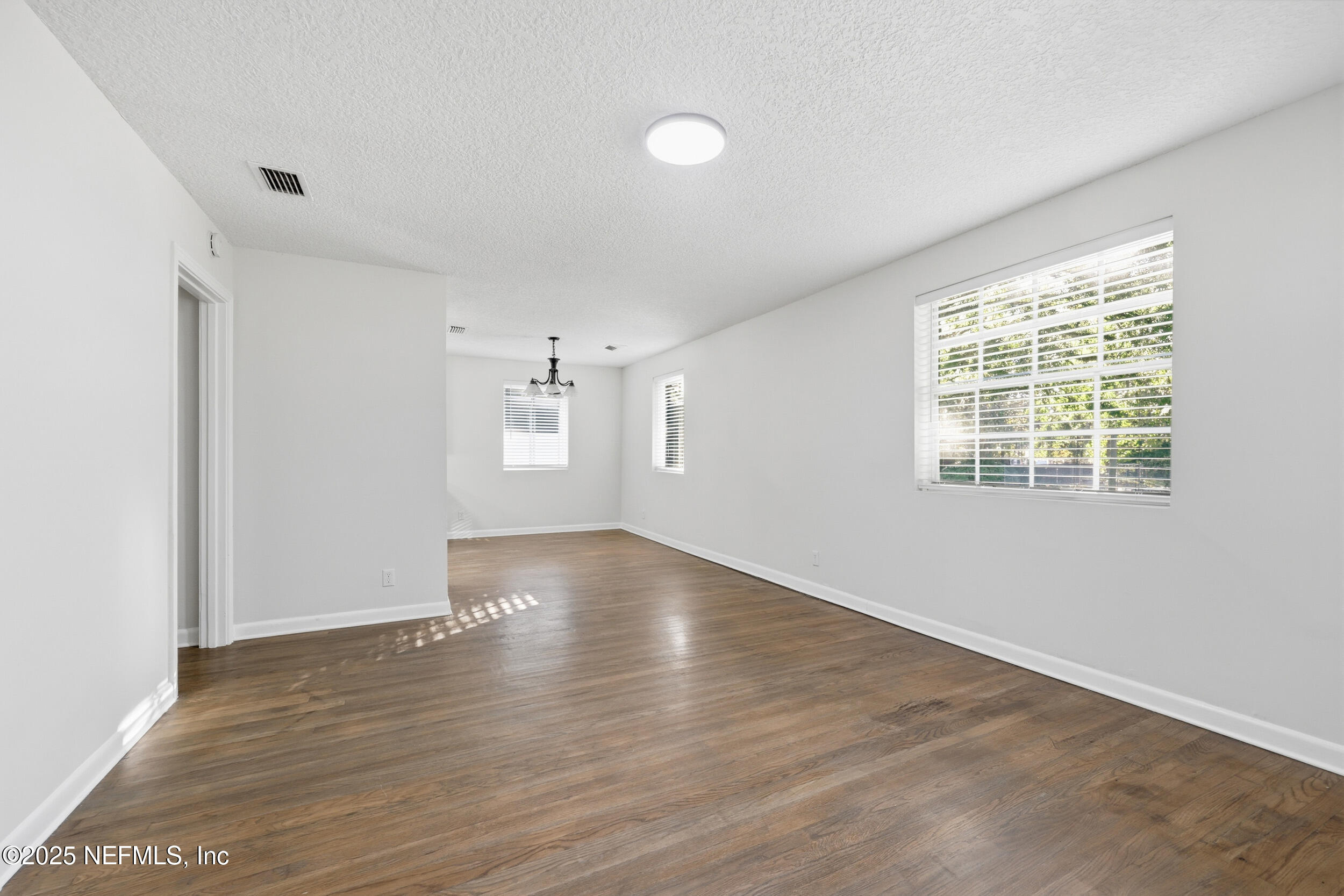 5201 Royce Avenue Jacksonville, FL 32205 - Photo 4 of 34 an empty room with wooden floor and windows