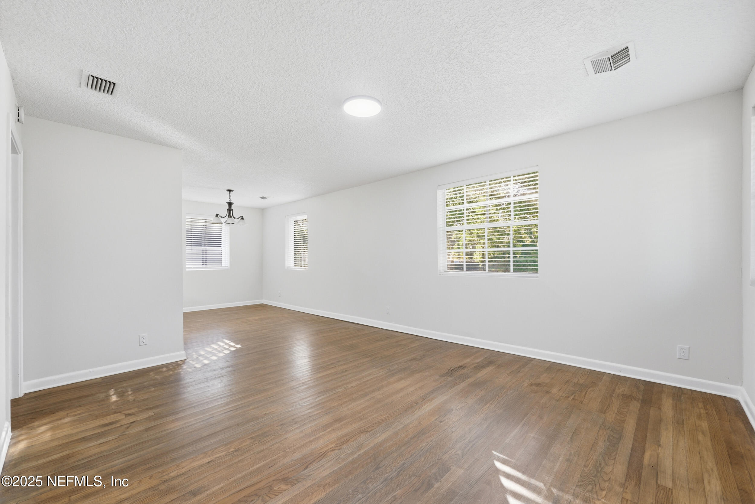5201 Royce Avenue Jacksonville, FL 32205 - Photo 5 of 34 an empty room with wooden floor and windows