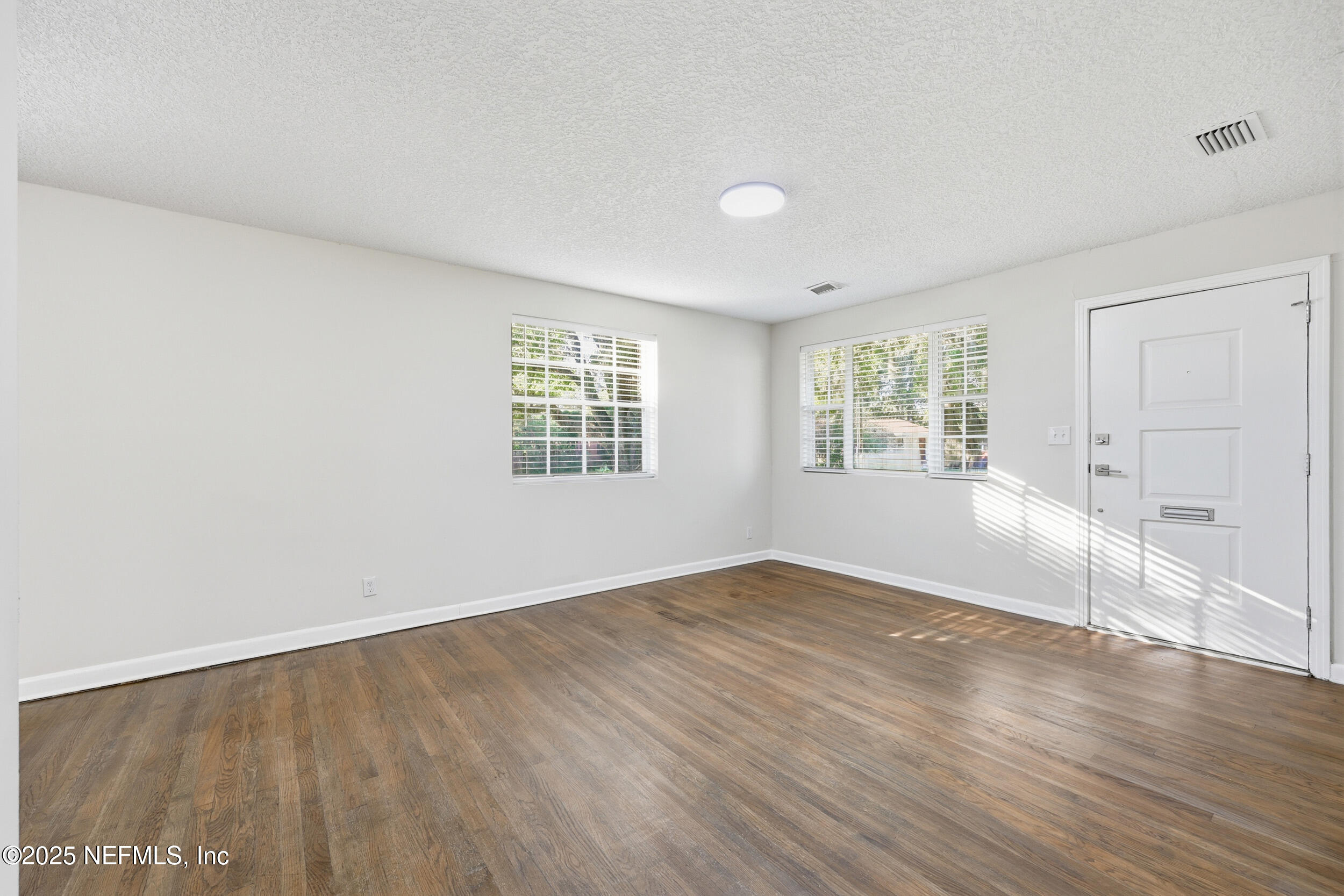 5201 Royce Avenue Jacksonville, FL 32205 - Photo 6 of 34 an empty room with wooden floor and windows