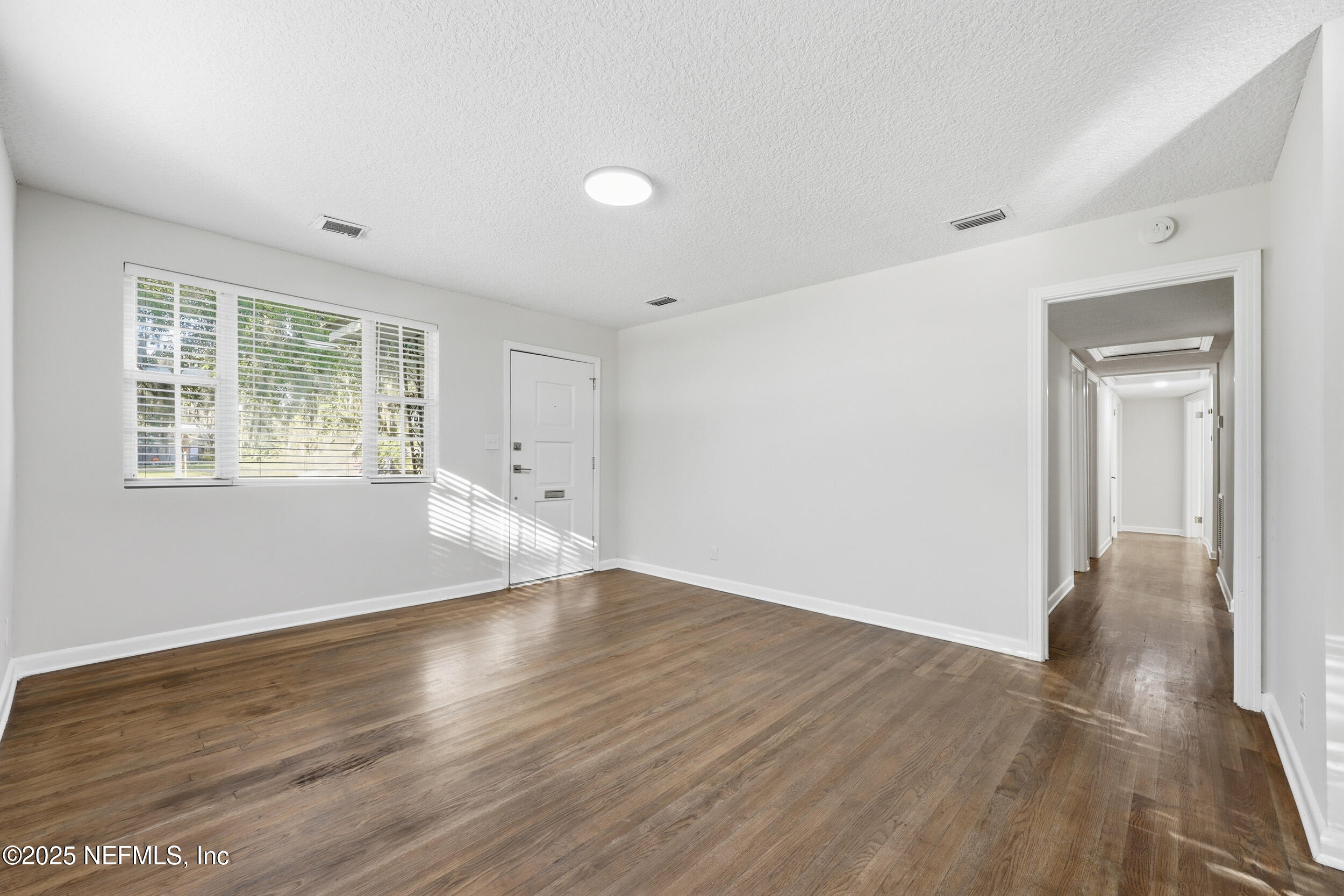 5201 Royce Avenue Jacksonville, FL 32205 - Photo 7 of 34 a view of an empty room with wooden floor and a window