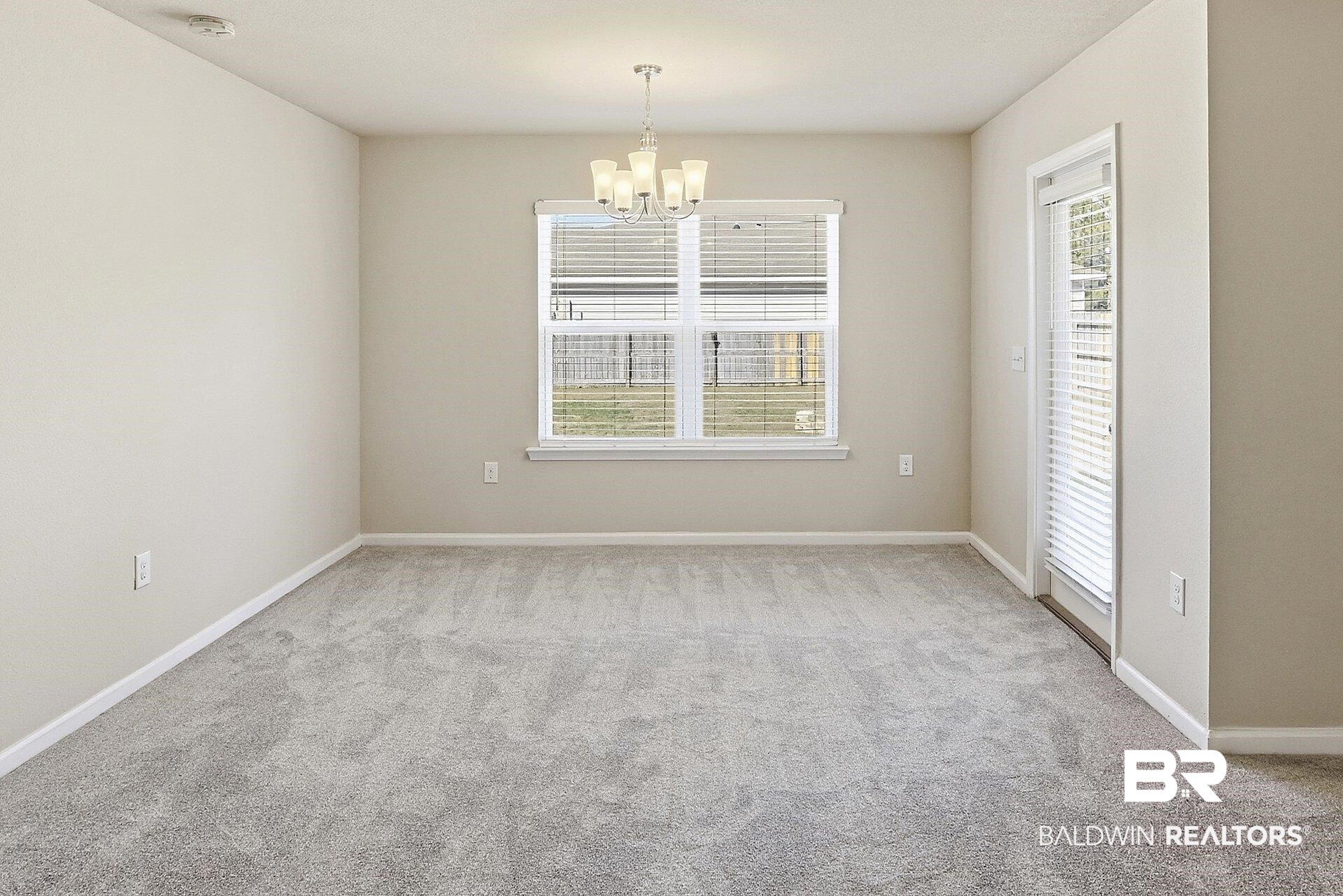 983 Summerton Drive Foley, AL 36535 - Photo 13 of 25 Spare room with light colored carpet and a chandelier