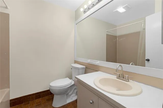 a bathroom with a sink a toilet and a mirror