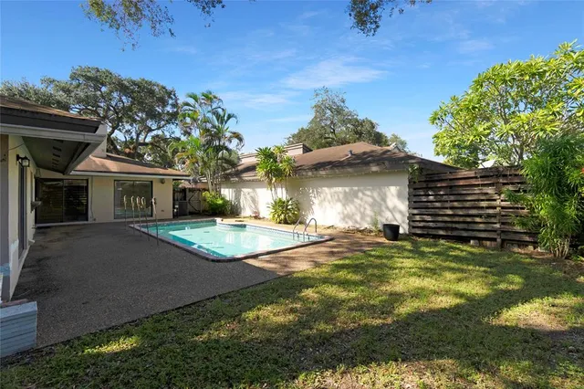 a view of a house with backyard and a tree