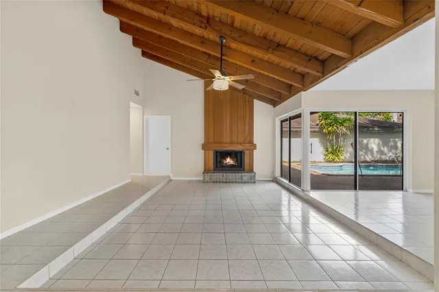 a view of an empty room with a fireplace and a chandelier