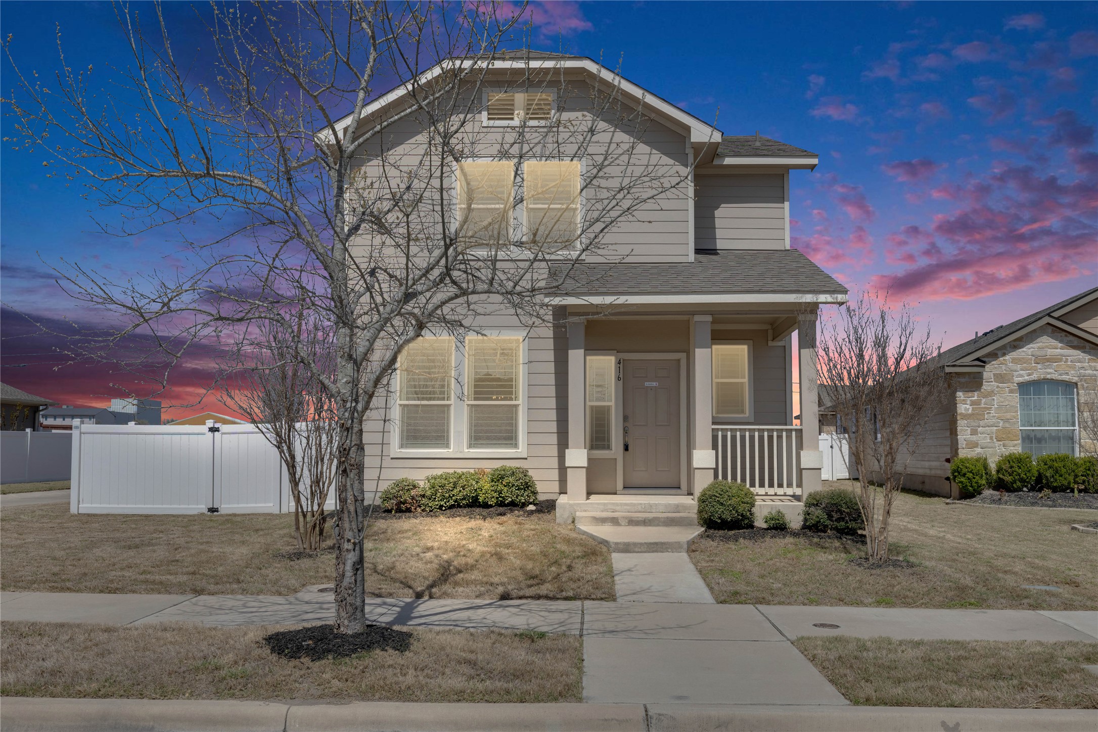 416 Cane River Road Pflugerville, TX 78660 - Photo 1 of 1 *Artificial twilight* Traditional-style home featuring fence, covered porch, and roof with shingles