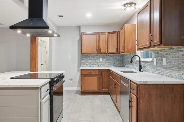 a kitchen with stainless steel appliances a sink a stove and cabinets