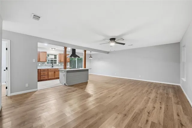 a view of a kitchen with an empty space and wooden floor