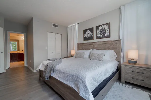 a bedroom with a bed and a lamp on dresser
