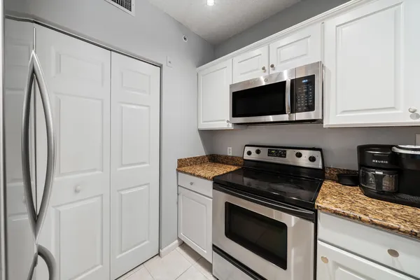 a kitchen with cabinets stainless steel appliances and a counter space