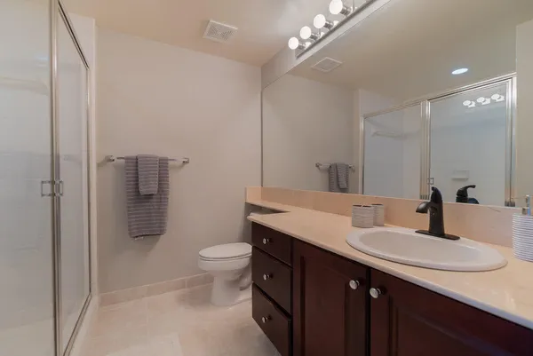 a bathroom with a sink a toilet a shower and a mirror