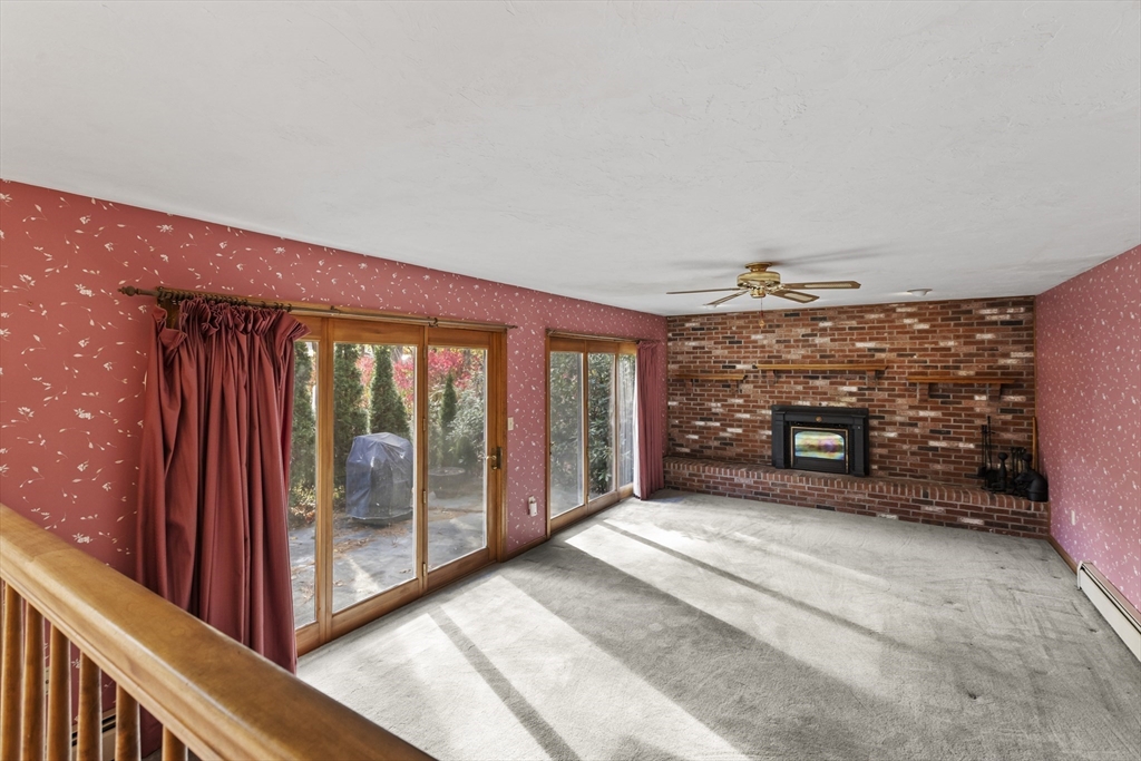 43 Maple Road Westford, MA 01886 - Photo 14 of 31 a view of a room with large windows and a fireplace