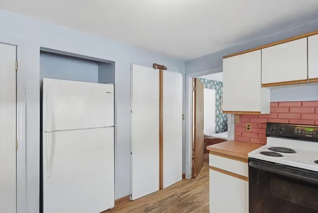 a kitchen with a refrigerator and a stove top oven