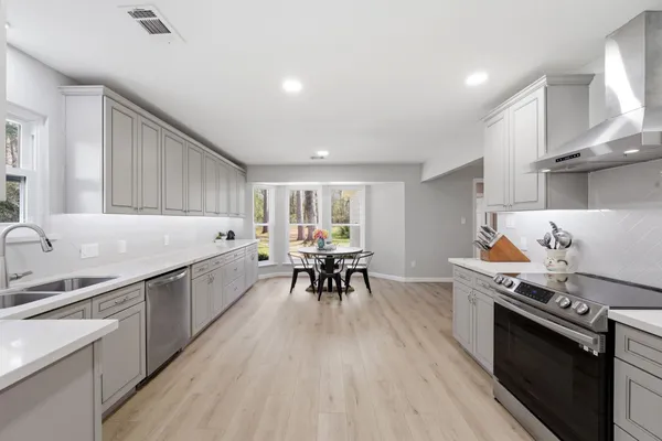 a kitchen with a sink stove and white cabinets