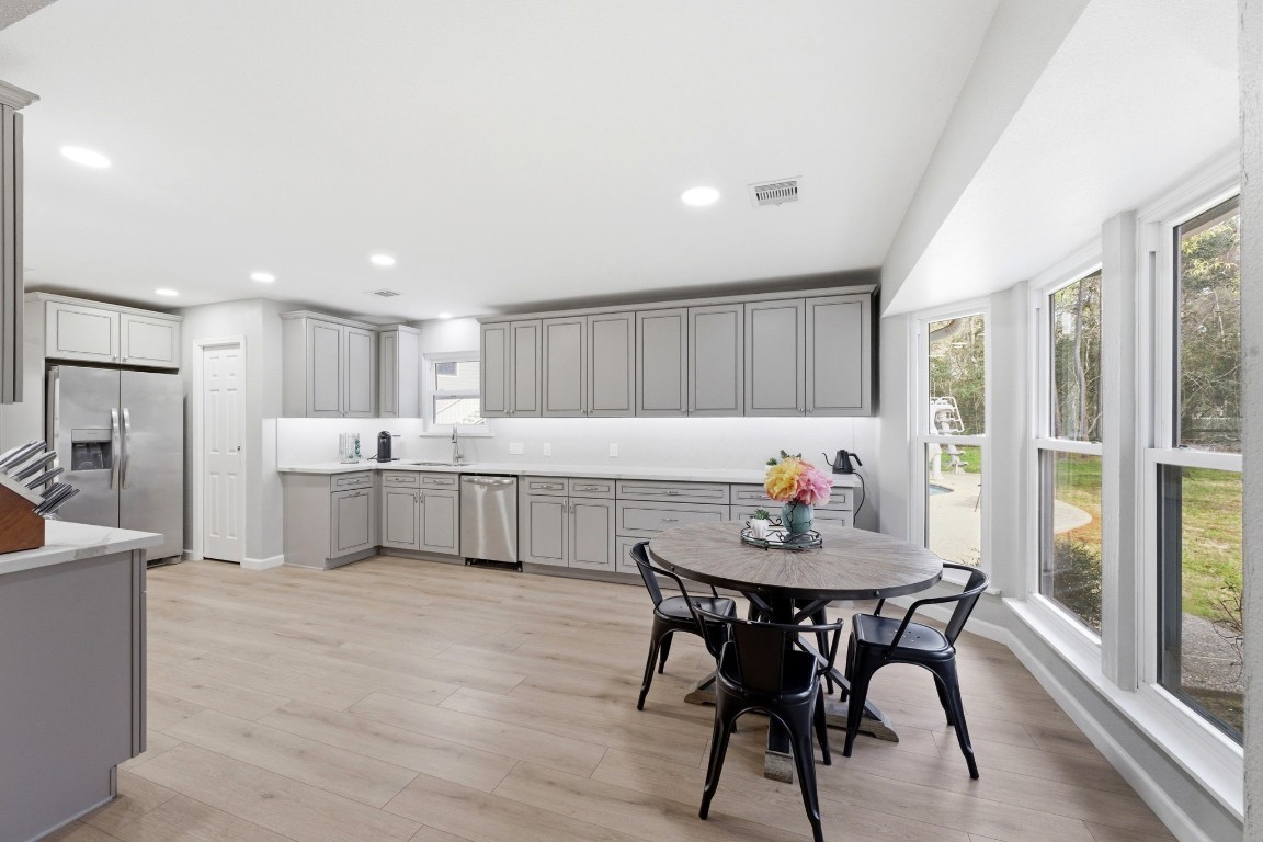 5222 Ranch Hill Drive Magnolia, TX 77354 - Photo 12 of 41 a kitchen with a dining table chairs and refrigerator