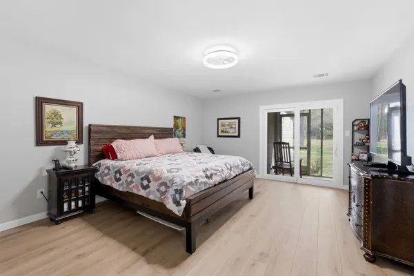 a bedroom with a bed a bookshelf and a flat screen tv