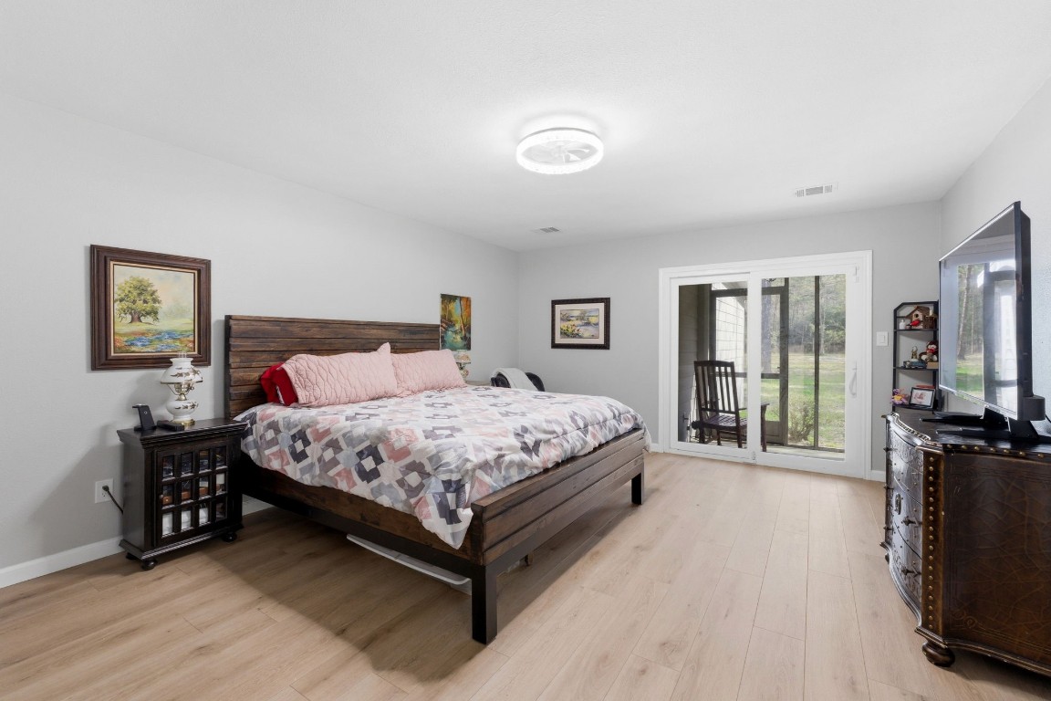 5222 Ranch Hill Drive Magnolia, TX 77354 - Photo 16 of 41 a bedroom with a bed a flat tv screen and a large window