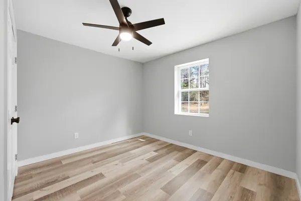 a view of a big room with wooden floor and windows