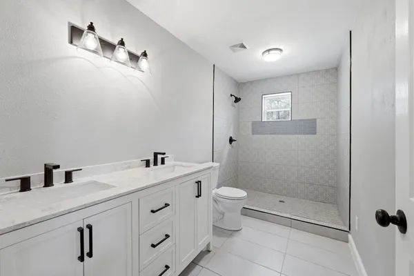a bathroom with a sink a toilet and shower