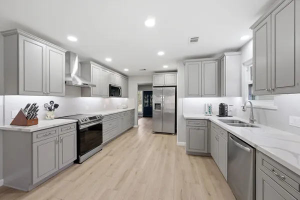 a large kitchen with stainless steel appliances granite countertop a sink and cabinets
