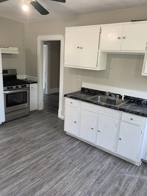 935 Liberty Street Springfield, MA 01104 - Photo 3 of 11 a kitchen with granite countertop a stove and a wooden floors