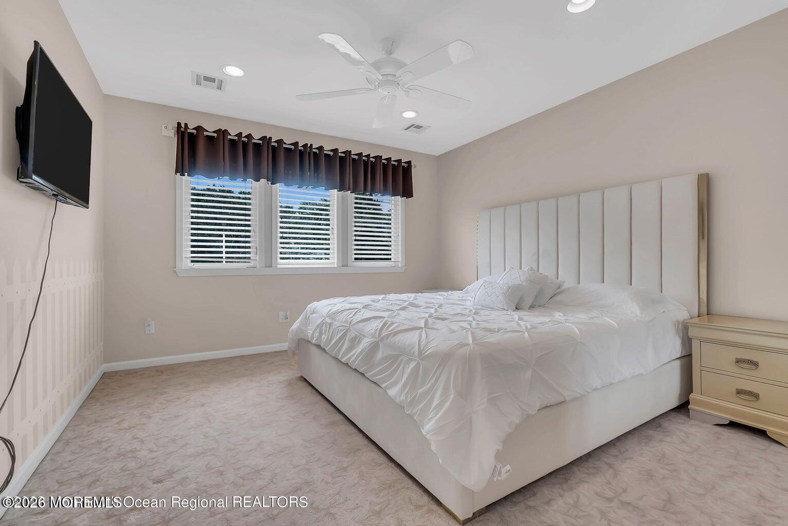 7 MacKenzie Road Eatontown, NJ 07724 - Photo 25 of 40 a large bed sitting in a room next to a window