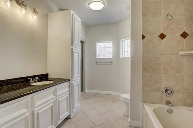 a bathroom with a tub sink and mirror