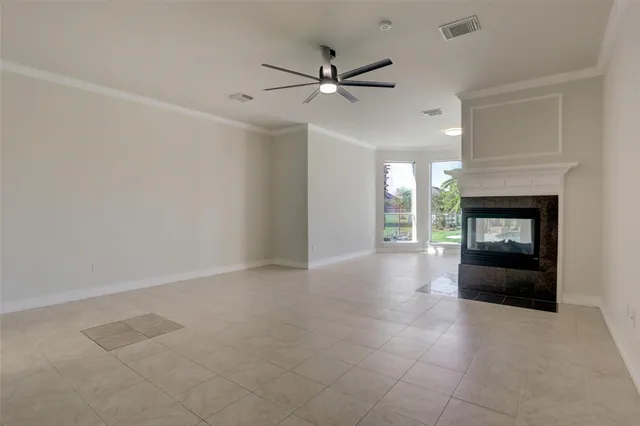 a view of an empty room with a fireplace and a window