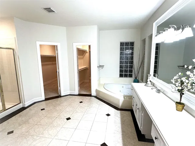a spacious bathroom with a tub sink and mirror