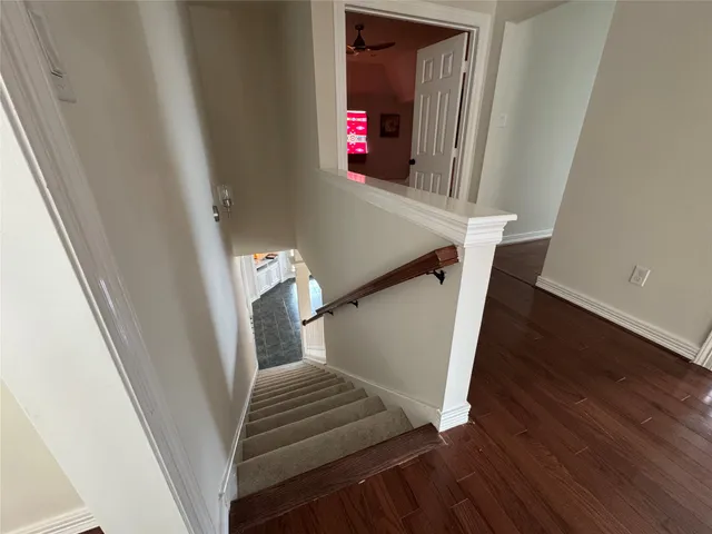 a view of stairs and a hallway with wooden floor