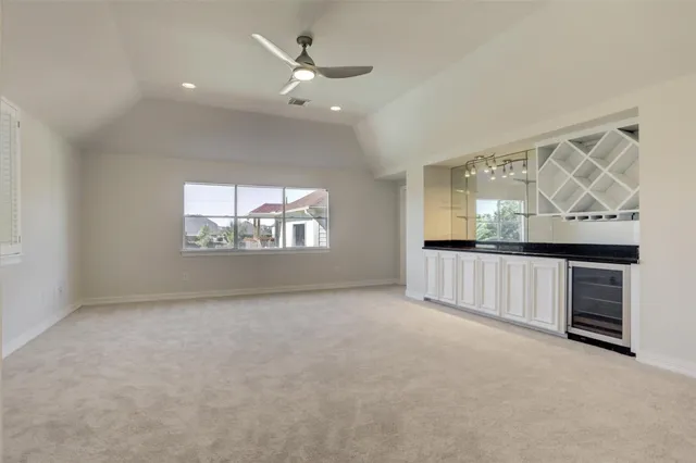 an empty room with windows and fan