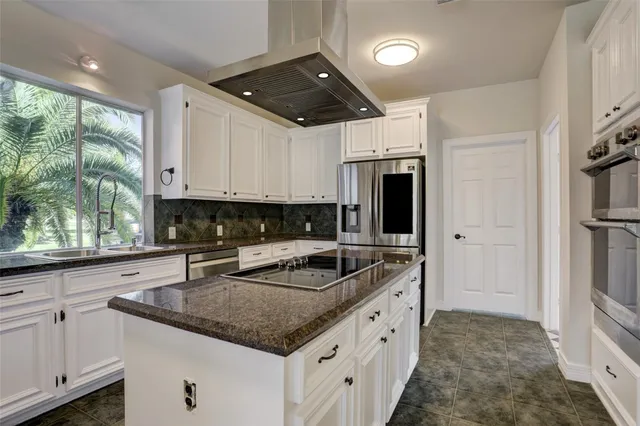 a kitchen with granite countertop a sink a counter space appliances and cabinets