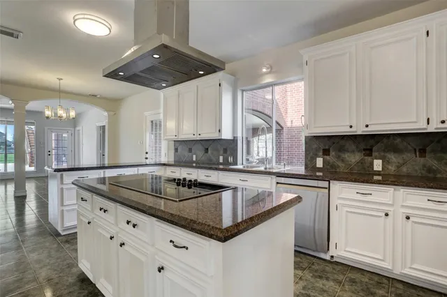 a kitchen with granite countertop a sink and white cabinets