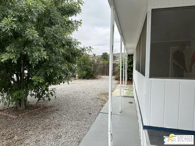 a view of a pathway of a house with a tree