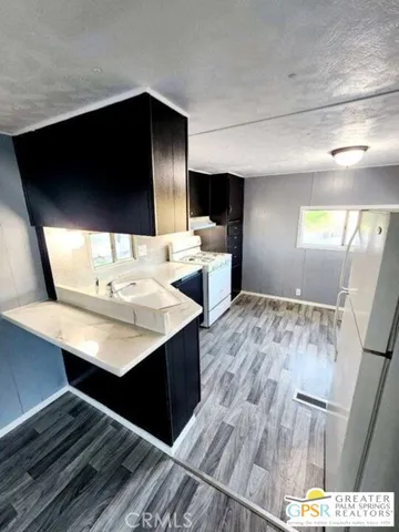 a view of kitchen with sink stainless steel appliances and cabinets