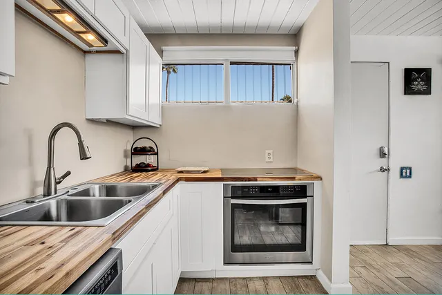 a kitchen with stainless steel appliances granite countertop a sink stove and cabinets