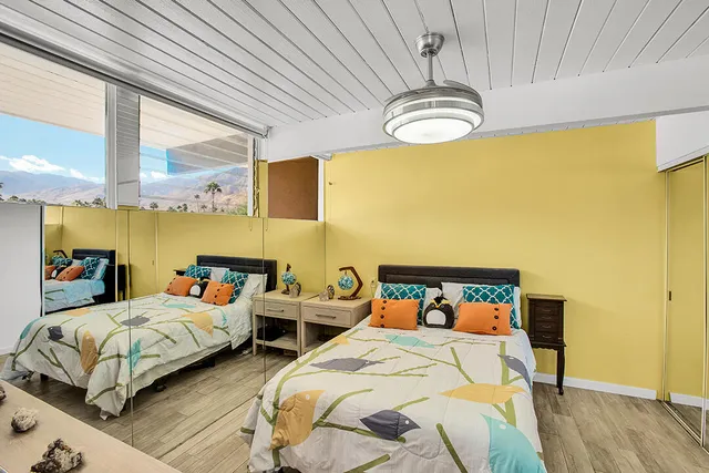 a bedroom with two beds and a chandelier