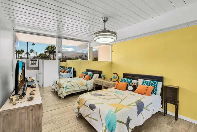 a bedroom with two beds and a chandelier