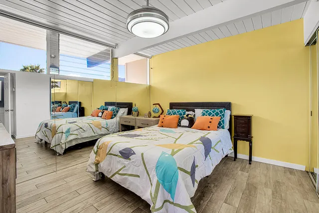 a bedroom with two beds and a large window